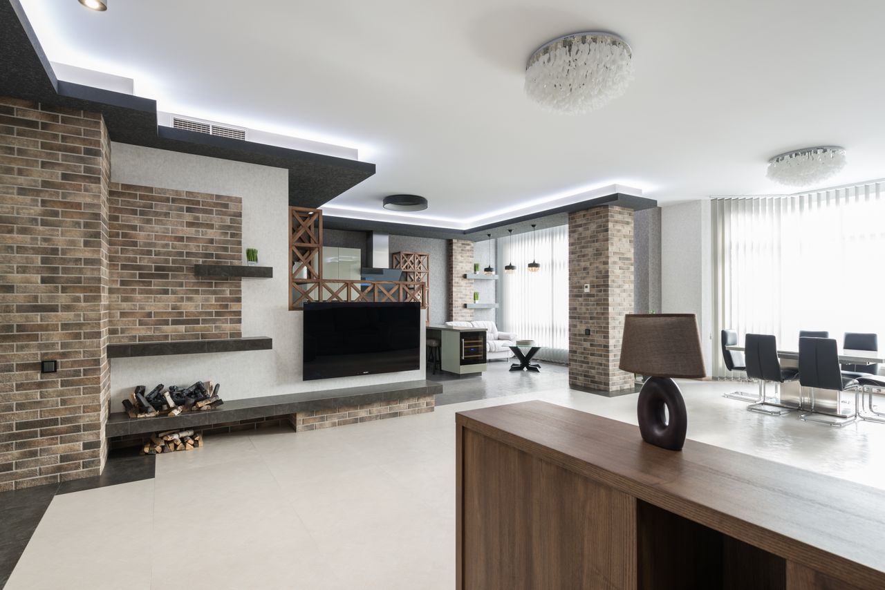 services-02 Modern TV at decorated wall in spacious living room with wooden cupboard in light apartment with table near big window